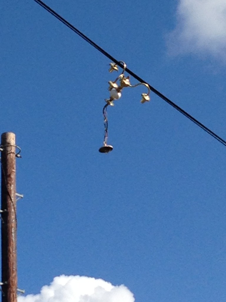 Light fitting hanging from telephone wires quimby Flickr