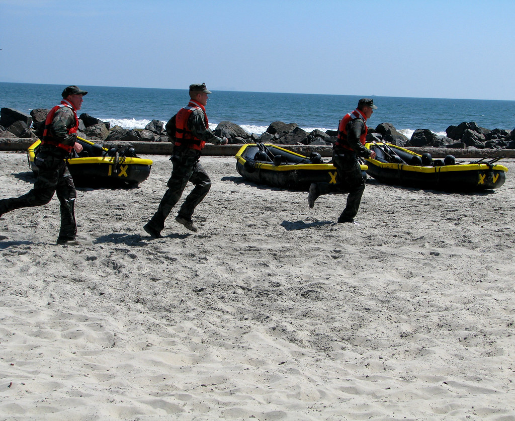 Navy SEALS Navy SEAL trainees run toward the ocean Stowe