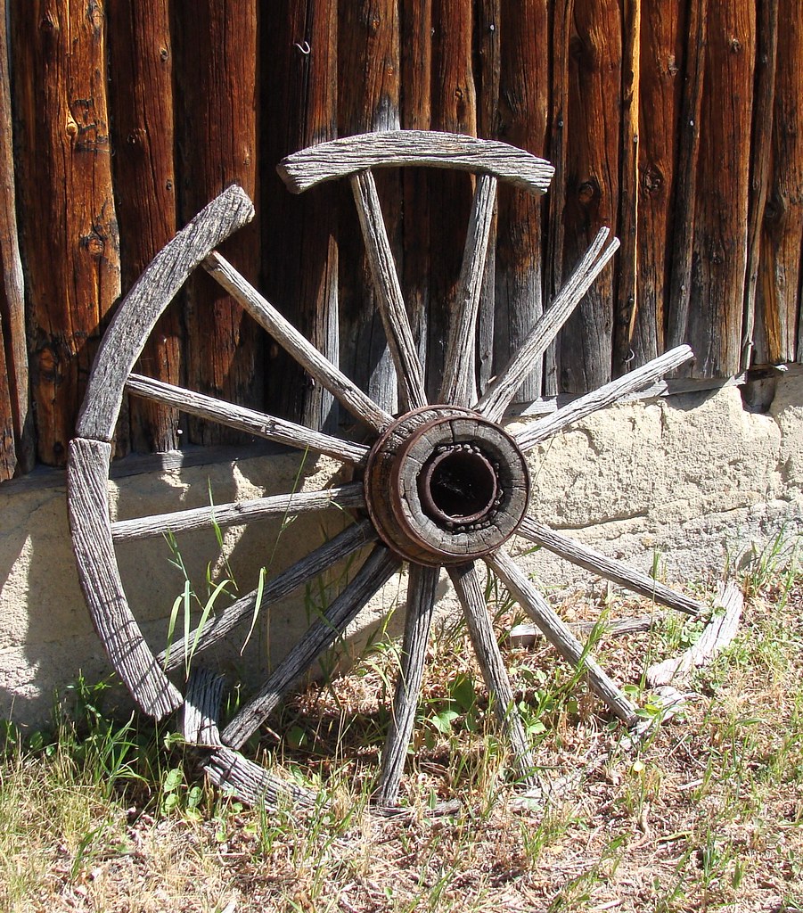 Old wagon wheel, part of rim missing, leaning against lodg… Flickr