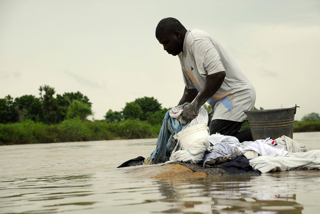 Man washing clothes in river Photo Copyright SPARC. … Flickr