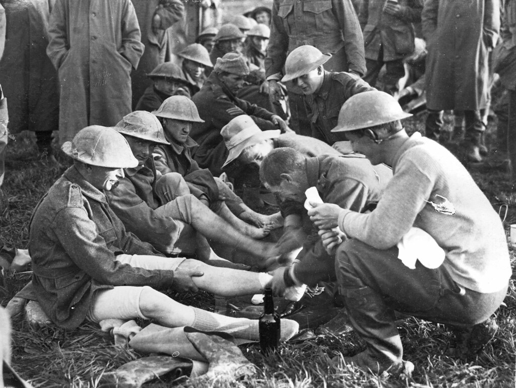 Soldiers in battledress and tin hats receiving medical tre… Flickr