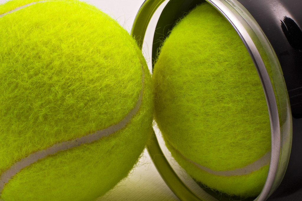 Yellow tennis balls out of black container Two tennis ball… Flickr