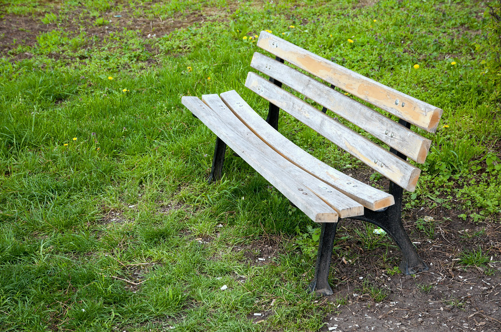 Empty wooden bench on a green lawn An old empty wooden