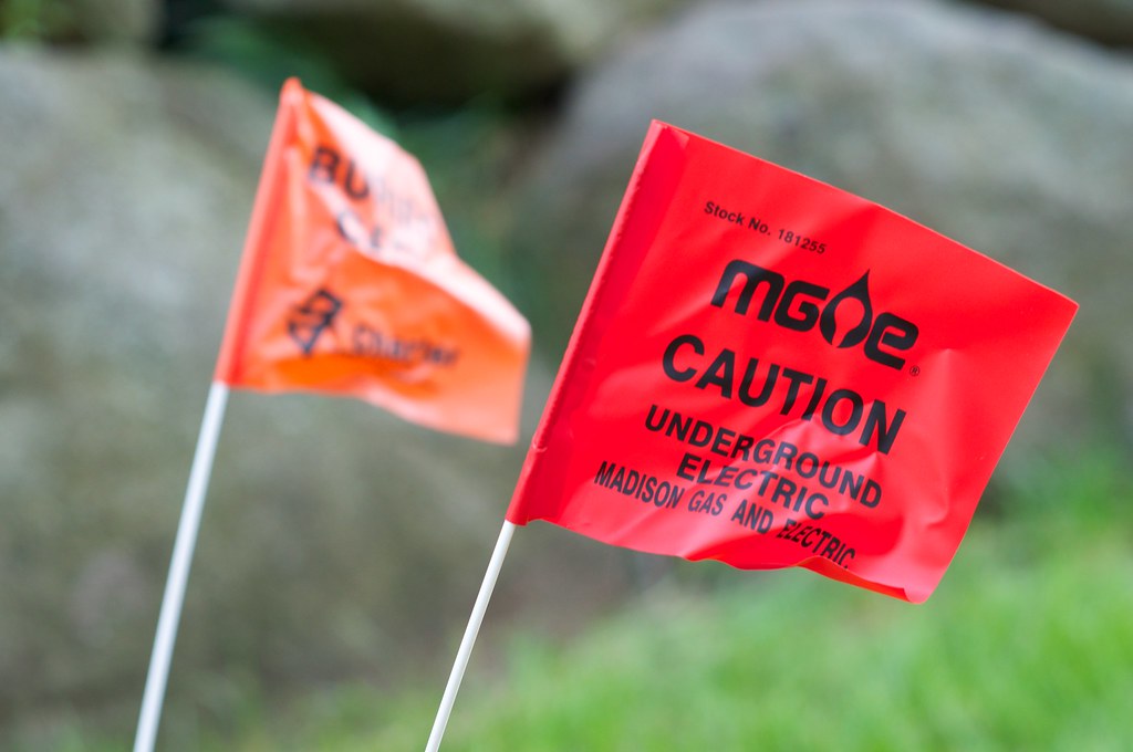 Caution Flags marking underground lines in our yard in pre… Flickr