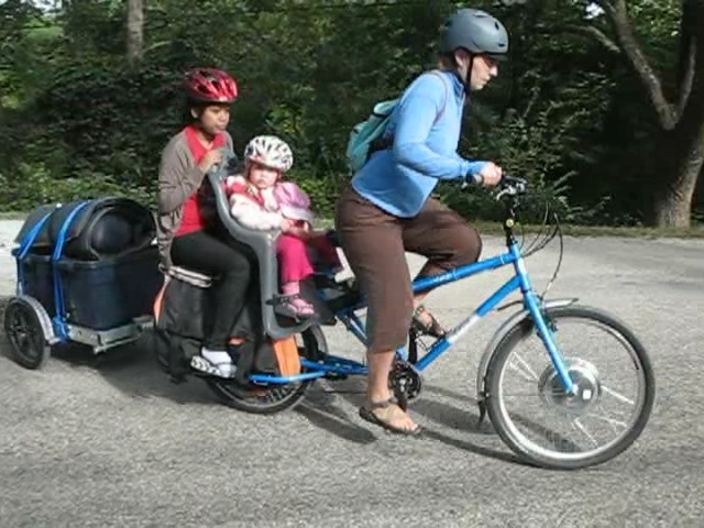 Electric Yuba Mundo cargo bike with two kids and trailer a photo on