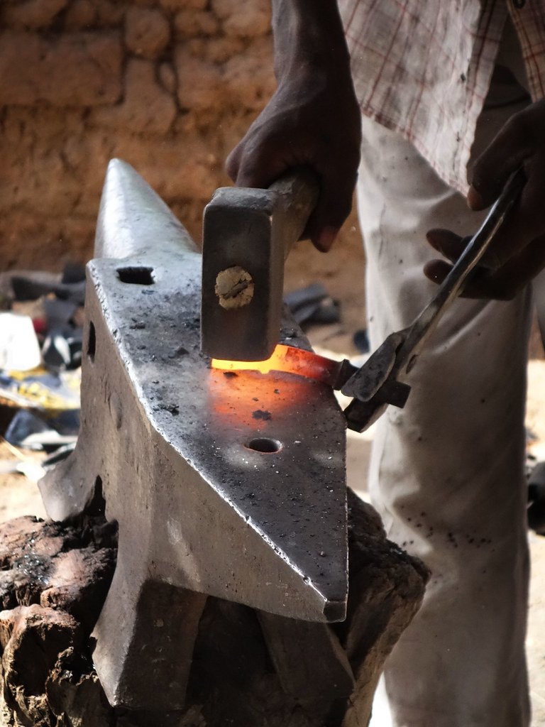 Red hot scrap iron being fashioned into an adze. Sprott Global