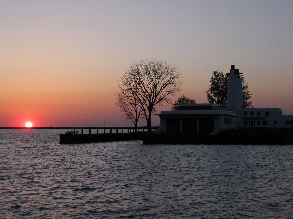 THE SUN SINKS INTO LAKE ERIE AS THE OLD COAST GUARD STATIO… Flickr