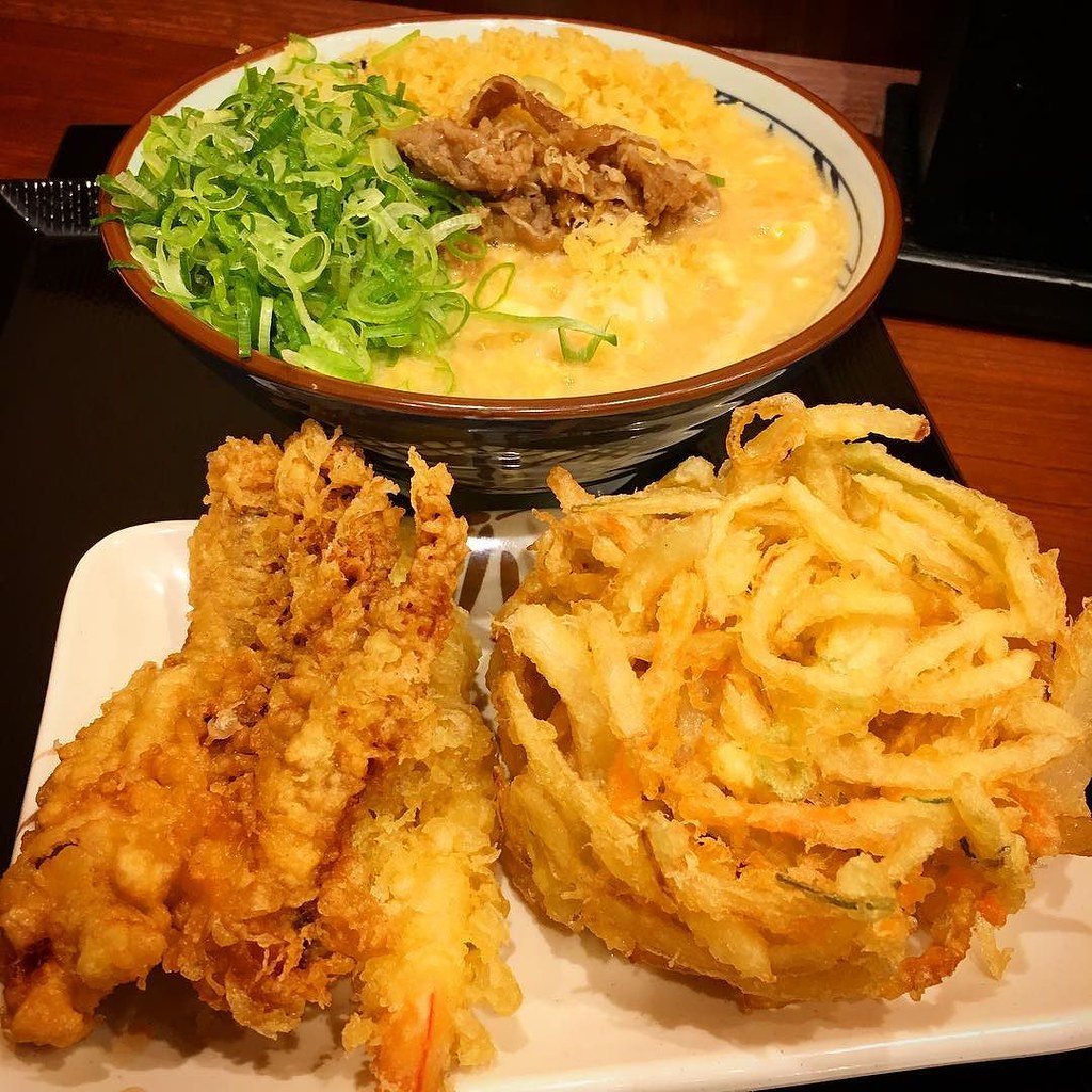 今日はプチ贅沢気分を味わうべく、丸亀で大盛りの肉玉あんかけうどんと、天ぷら三点盛りコース。 実は息子と2人でシェアす