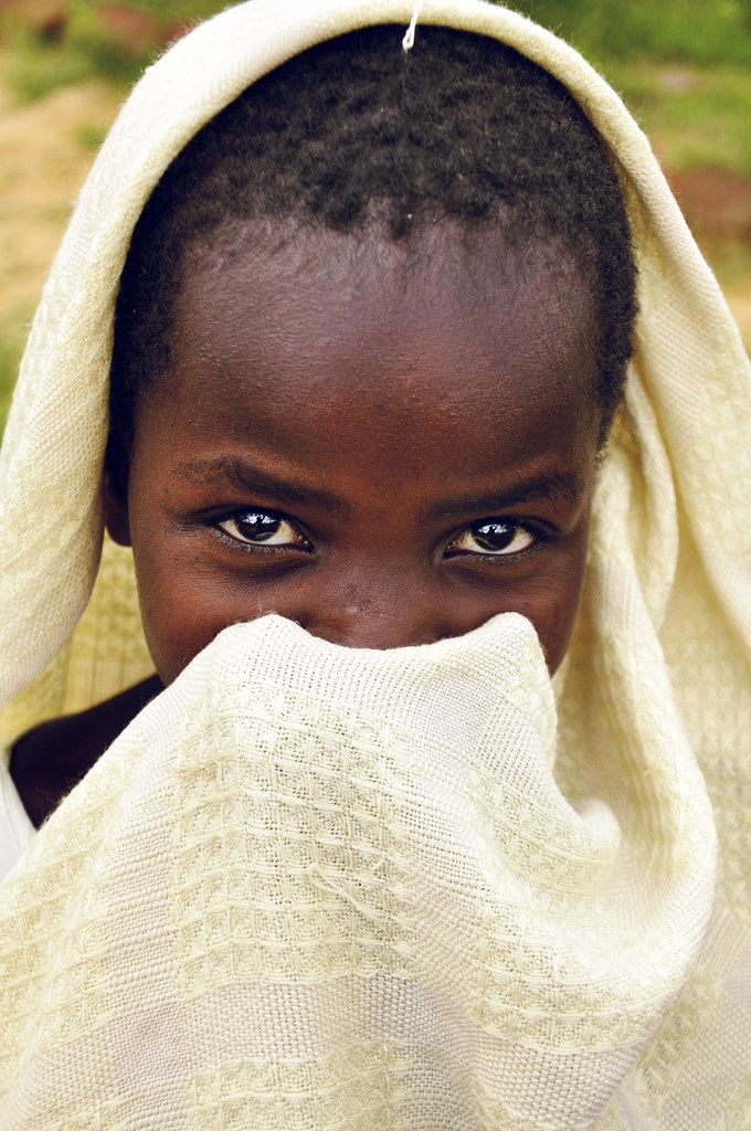 A young child in Kenya carrying around a blanket. Has tho… Flickr