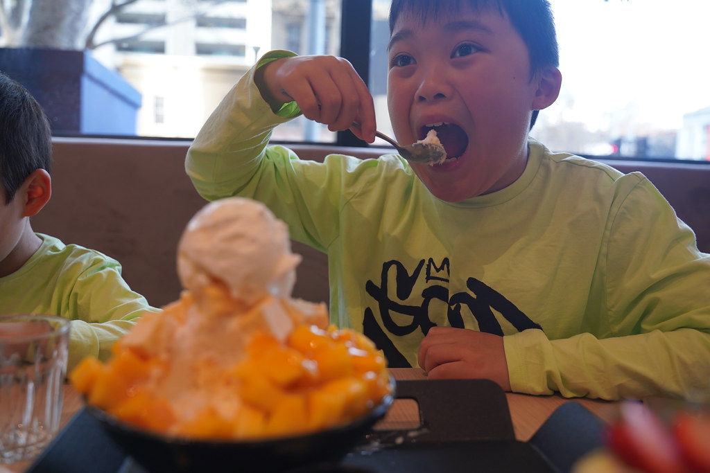Isaac taking a bite of mango bingsu at Sul Bing, Melbourne a photo on