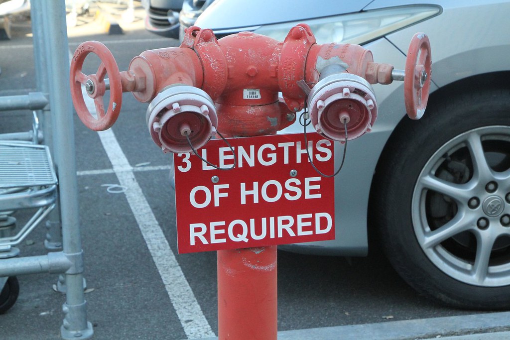 '3 lengths of hose required' sign on a fire hydrant in the Bunnings