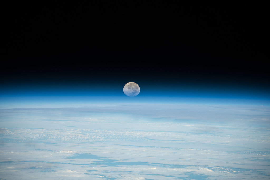 The Full Moon is pictured setting below Earth's horizon Flickr