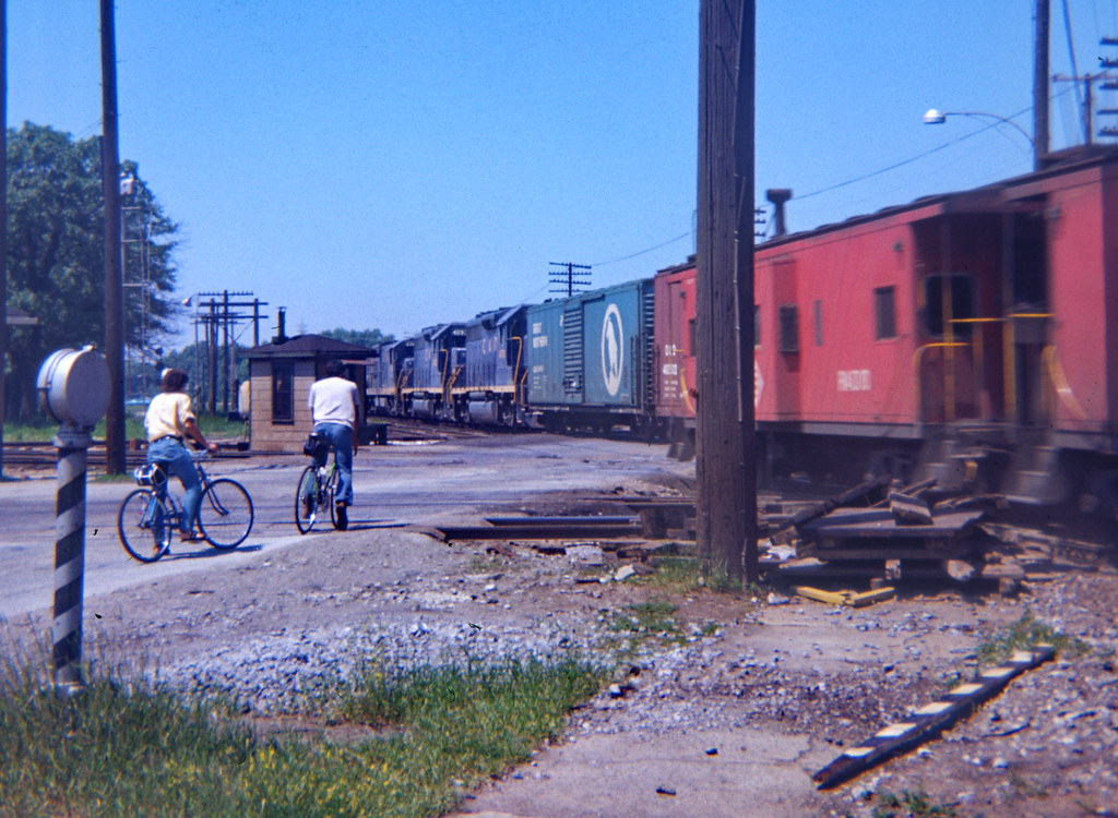 Griffith, IN EL cabooses passes just as C&O crosses west b