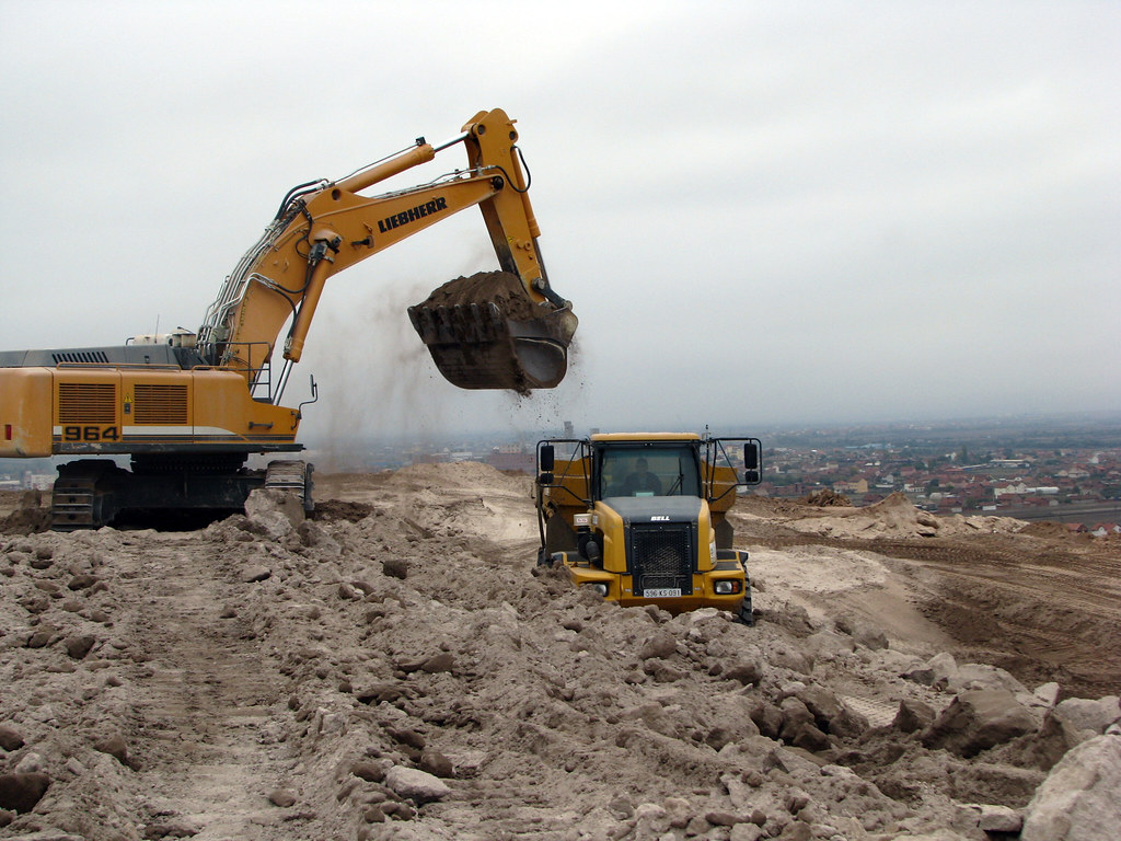 Excavators work to clean up an ash heap Excavators and jum… Flickr
