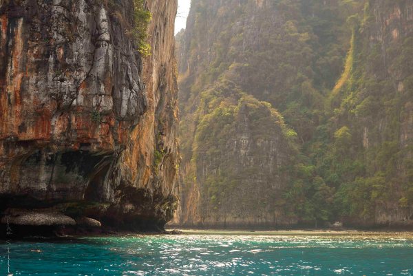 A kayaker beneath Phi Phi's majestic cliffs.