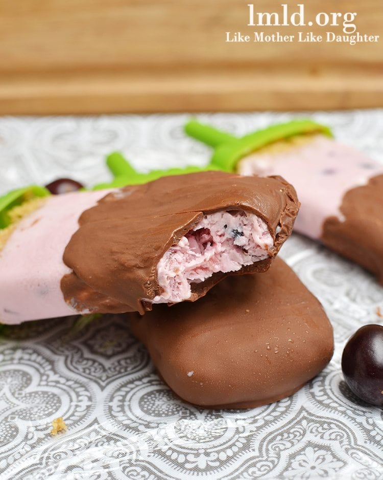 Close up view of chocolate covered cherry cheesecake popsicles.