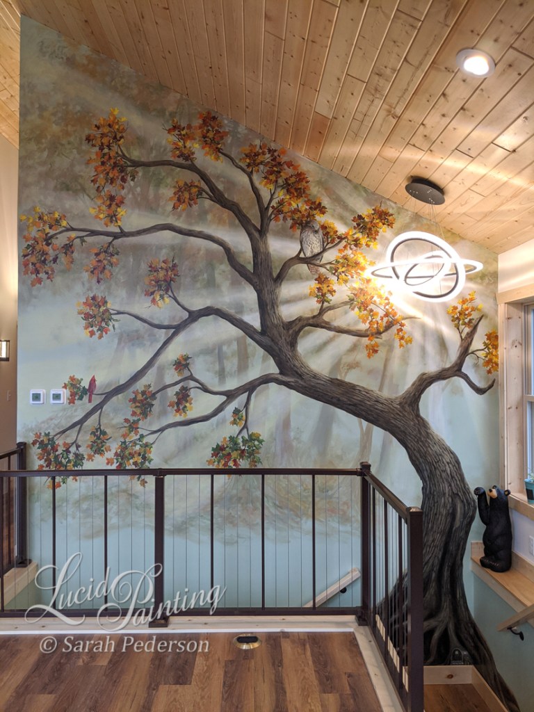 Large tree fills a stairwell. Sunrays appear to come from an existing light fixture. A red tailed hawk and a male cardinal sit on branches of the tree. Additional trees appear muted and fading away into the distance.