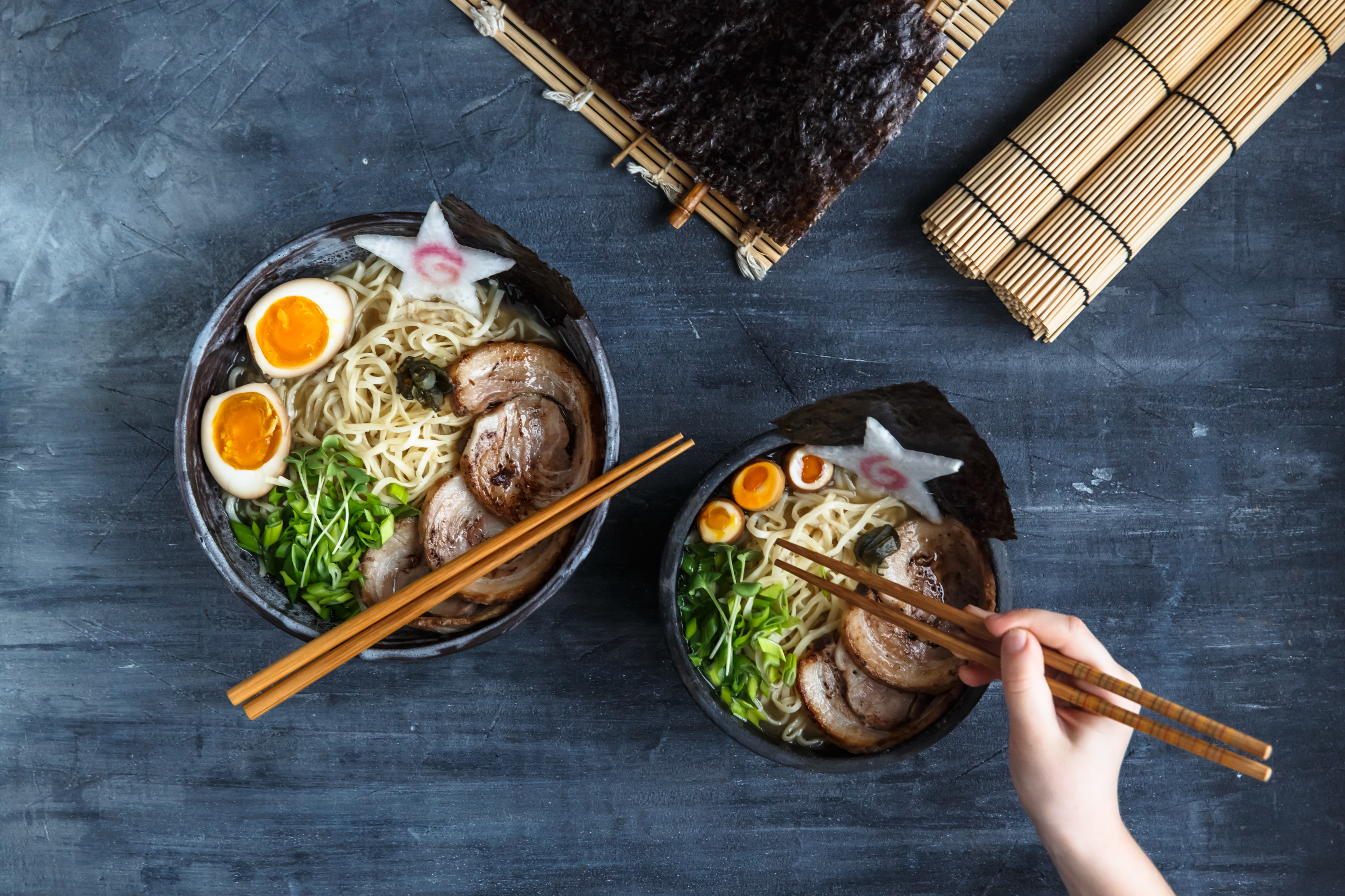 Hand with chopsticks try miso ramen Sacramento Real Estate