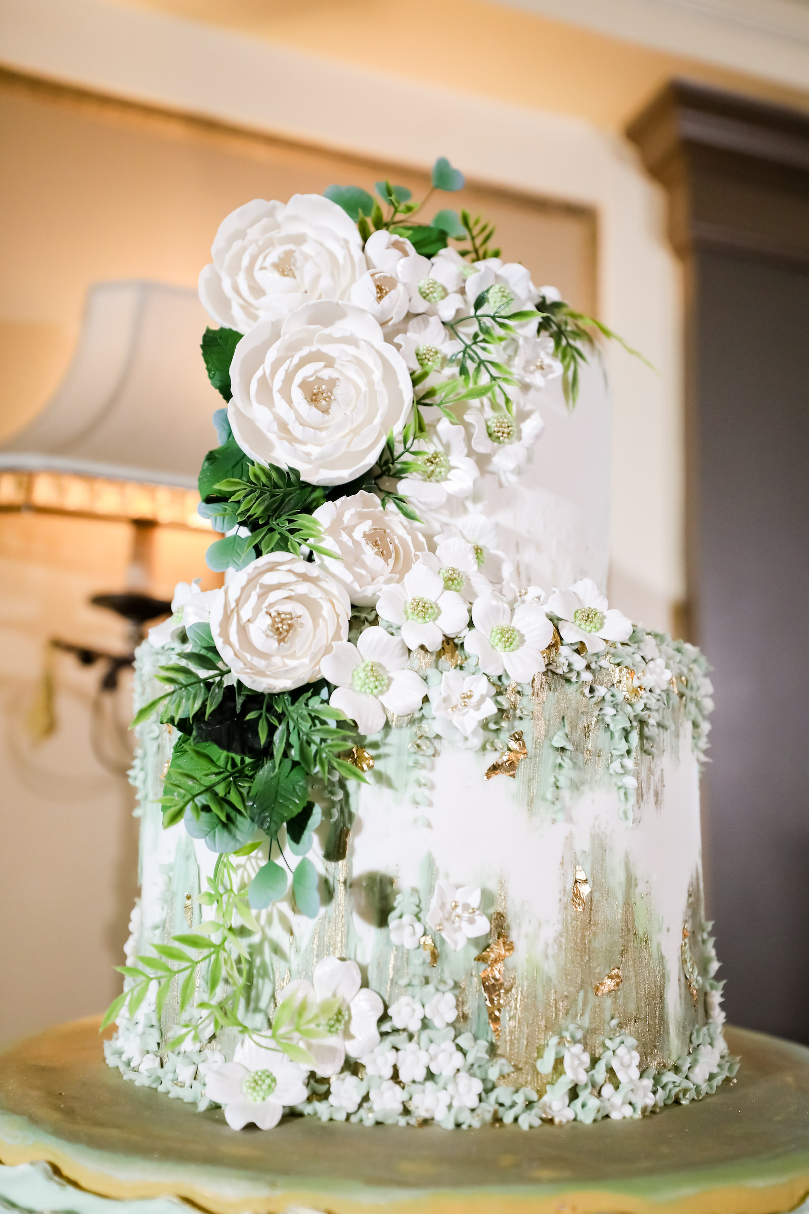 Unique Creative Two Tier Wedding Cake with White Flowers and Greenery