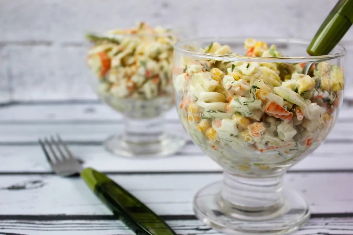 Pasta salad in creamy form with crab stick and avocado