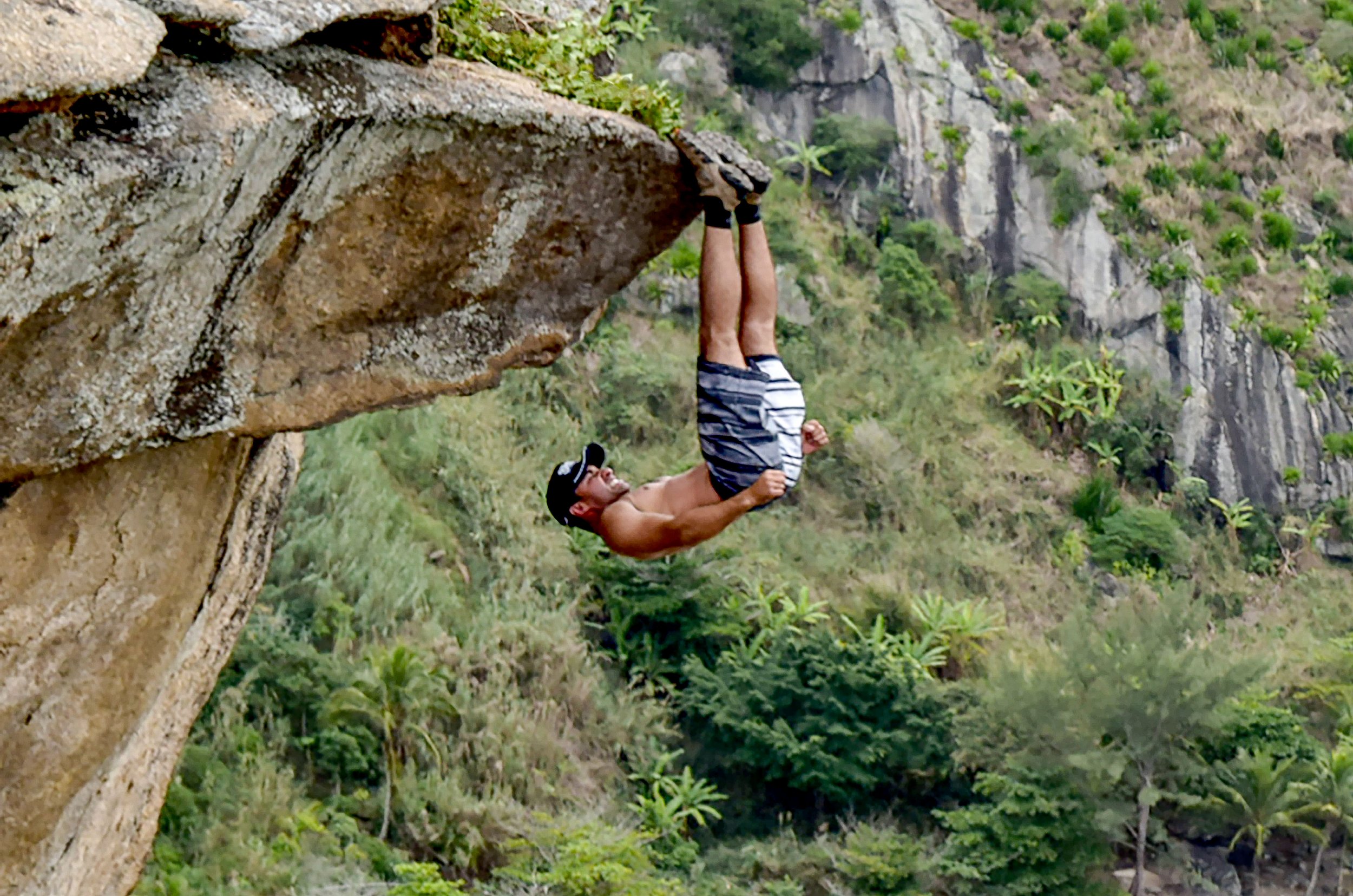 This photo of a man hanging off a cliff by his feet will make you feel
