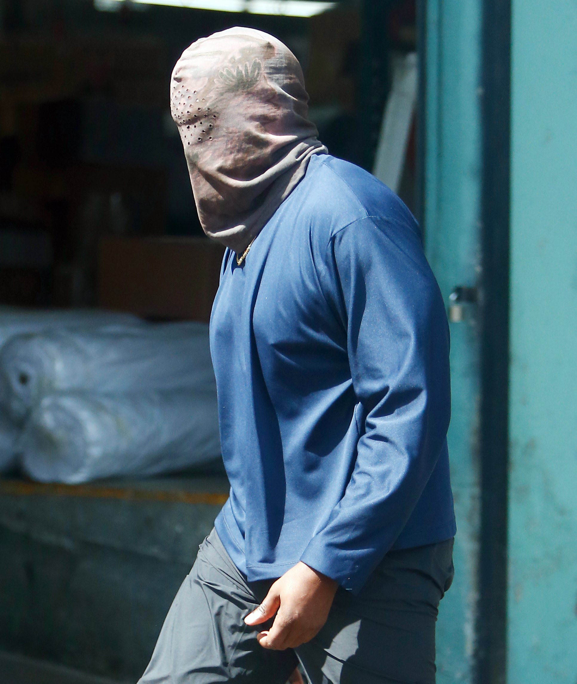 Kanye West is not bothered by LA heatwave as he wears full head mask