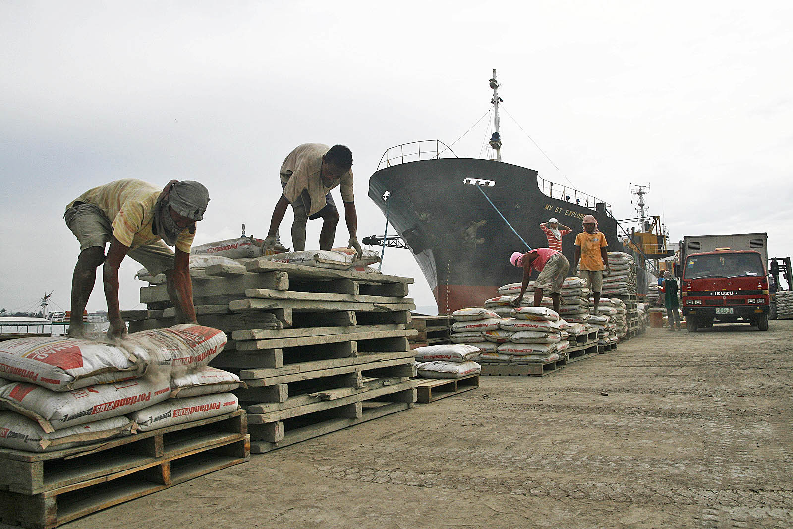 workers unload cement in davao city MindaNews