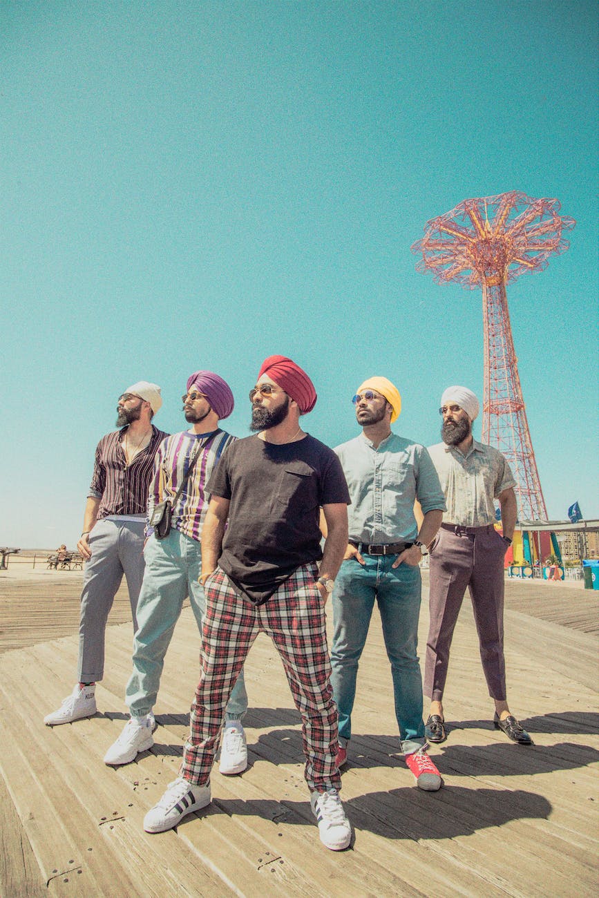 five men wearing assorted color turban headdresses