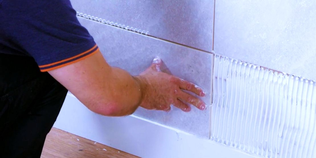 Do you put adhesive on tile or wall?