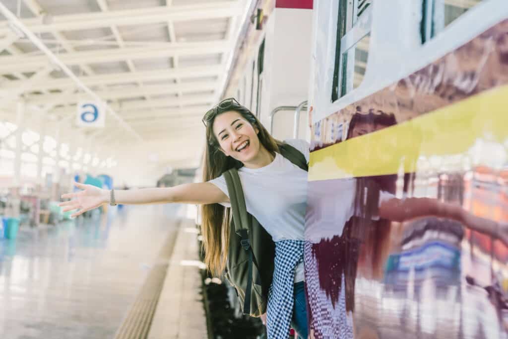 woman Traveller feeling happiness before go to travel at the train station, Travel and lifestyle concept