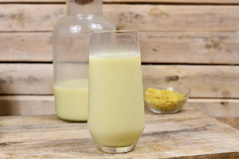 Romige haverkurkuma melkachtige drank ( textuur van volle melk