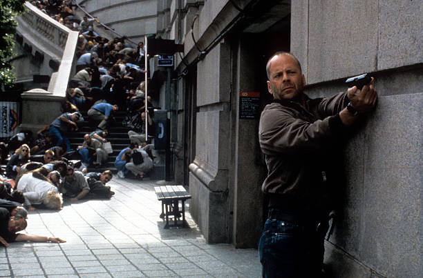 Bruce Willis aiming gun as others duck for cover in a scene from the film 'Mercury Rising', 1998. (Photo by Universal/Getty Images)