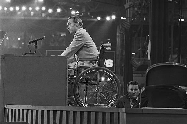 7/11/72 - Miami Beach: Seated in his wheelchair atop podium Alabama Governor George Wallace addreesses the Democratic National Convention 7/11. Wallace recieved a standing ovation from the audience as he was wheeled into the hall.
Photo Credit: Getty Images
