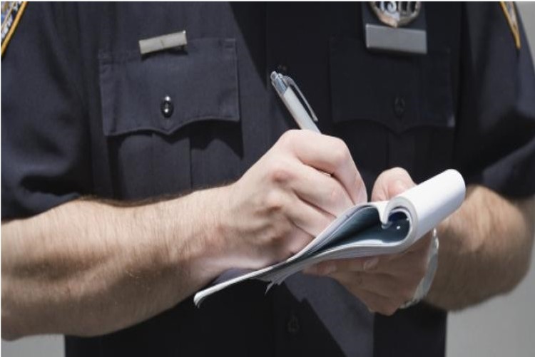 A Police Officer Giving Ticket At A Intersection