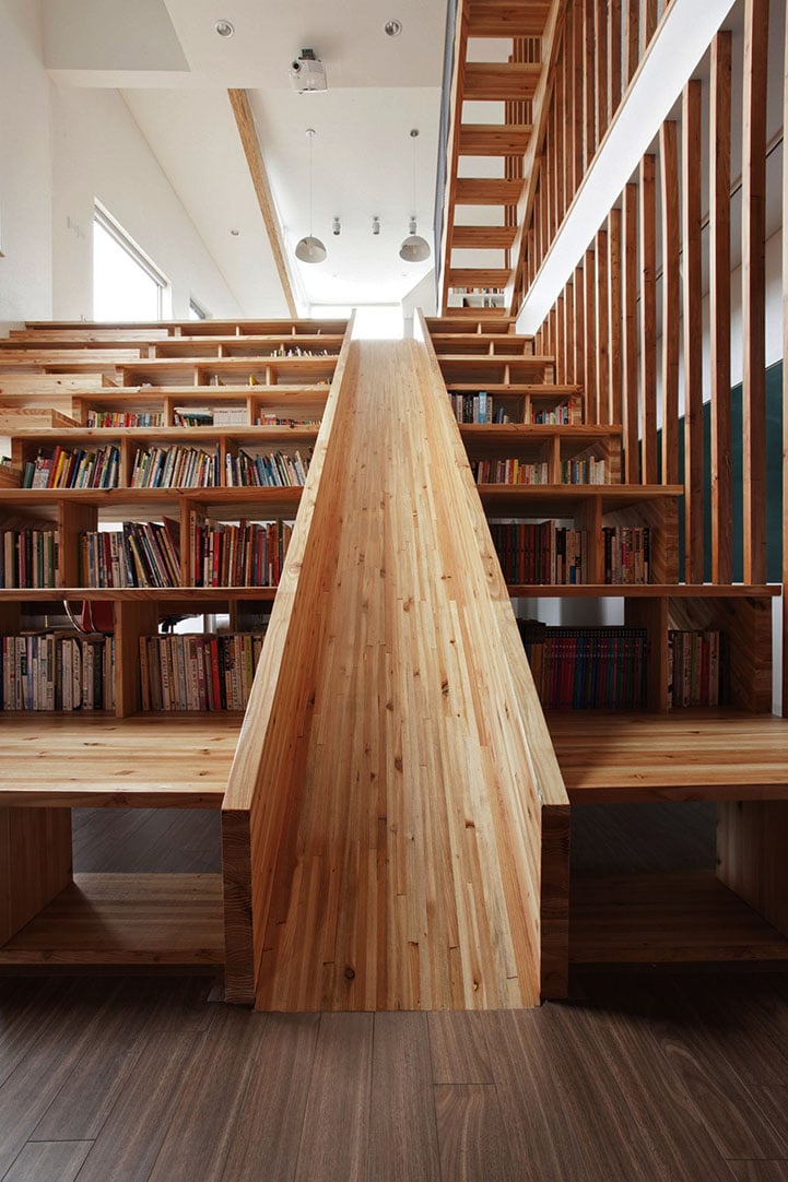 Playful Wooden Slide Formed Within a Bookshelf