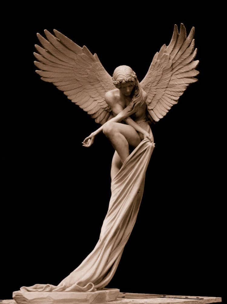 A sculpture of an ethereal angel seems to float above the ground