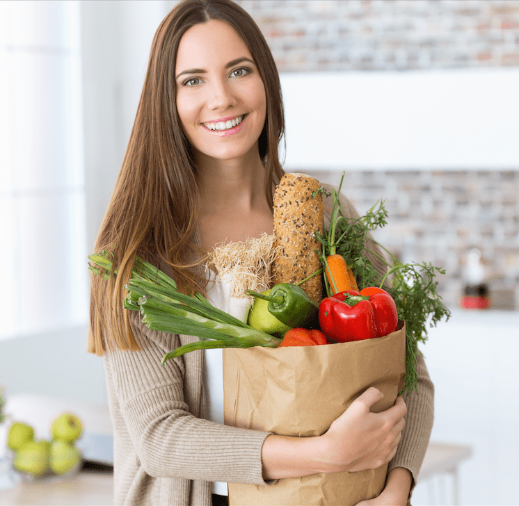 Food Security Young woman with vegetables in grocery bag at home. NEDC