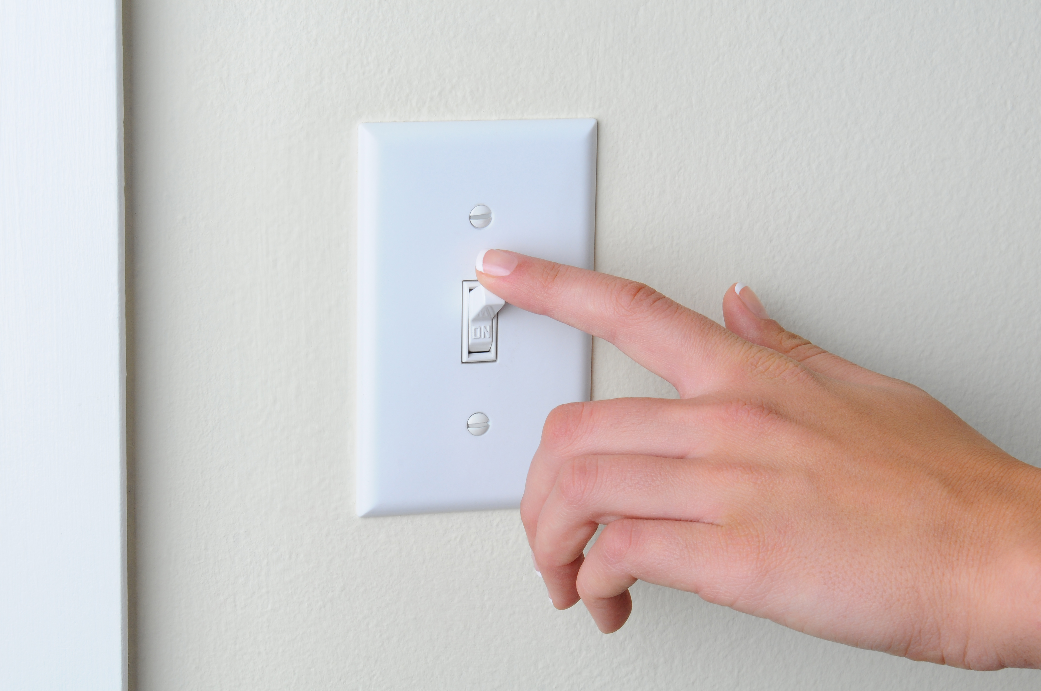 Woman turning off light switch HR Daily Advisor