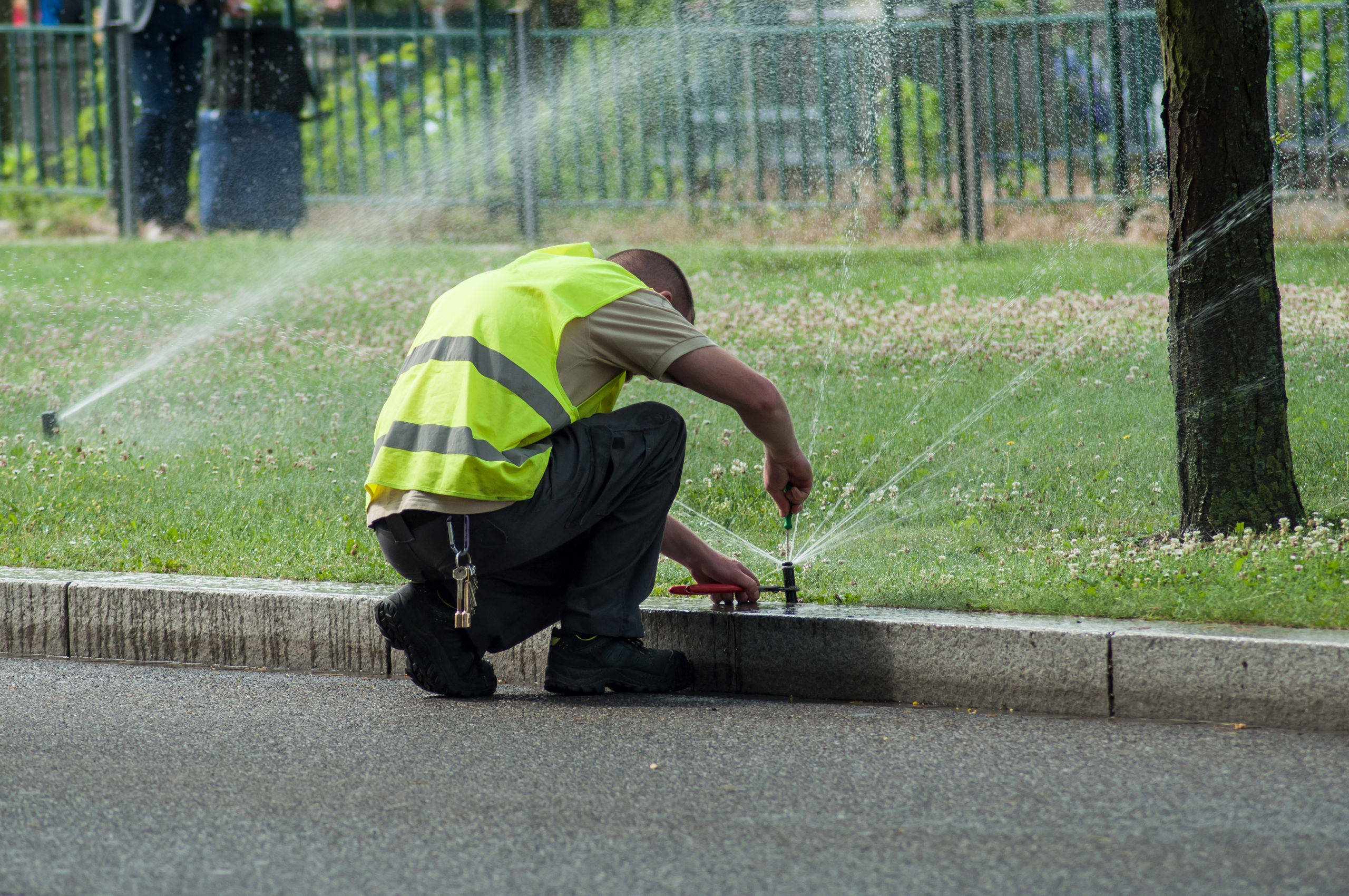 transportation company employee adjusting automatic sprinklers on