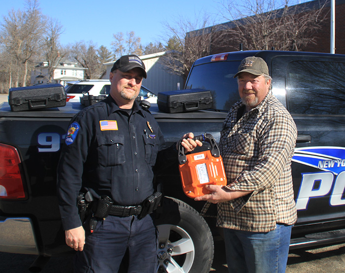 Kenny Friese presented New York Mills Police Chief Bobby Berndt with three Fire Suppression
