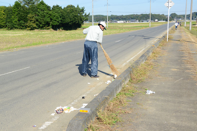 会長さん自ら掃き集めています。見たところチューハイやビールの空き缶。コンビニで売っているようなつまみのカラ（ビーフジャーキーやチーズ鱈）膨大なティッシュ、それから生命保険会社からのお知らせやメモなど・・・。弁当ガラとつまみが一種にごみ袋に入っているくらいなので独身でしょう（ビールもハイオクですし）。多分男性。メモには15：00や車検、とけいの文字。日時や時計が必要ということはもしかしたら失業したばかりとか？　それとも風邪をひいて会社を休んでいる？　いずれにしてもいい大人でしょう・・・困ったものです。