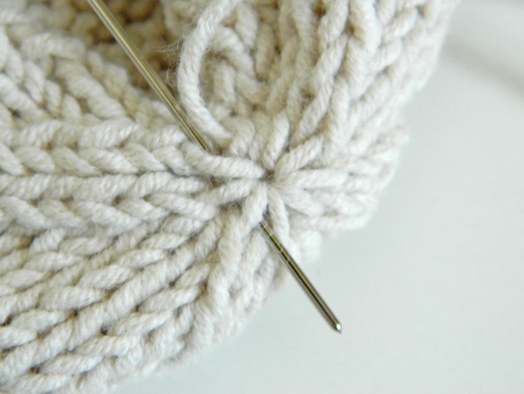 detaild of the process of closing a knitted hat