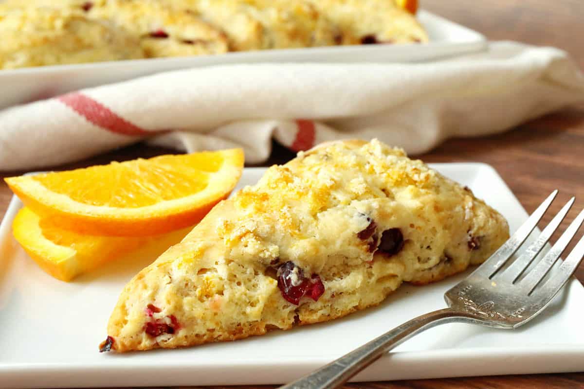 Orange cranberry scones on a white plate.