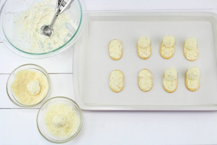 Round small cheese balls being added to crackers