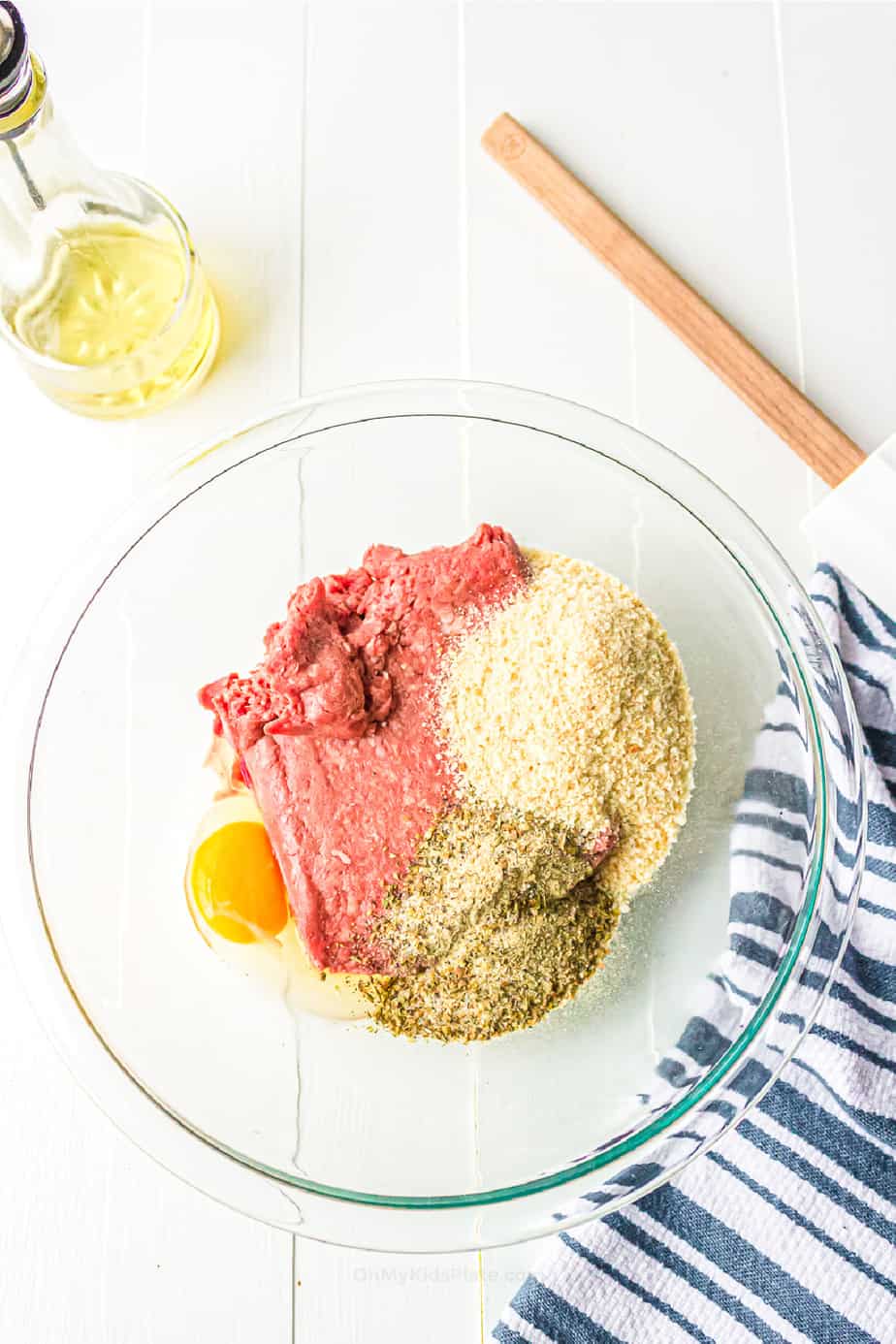 Beef meatball ingredients layered in a bowl.