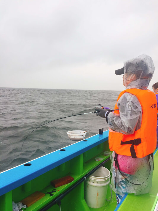雨の中でがんばって釣りをする女性 ORETSURI 俺釣