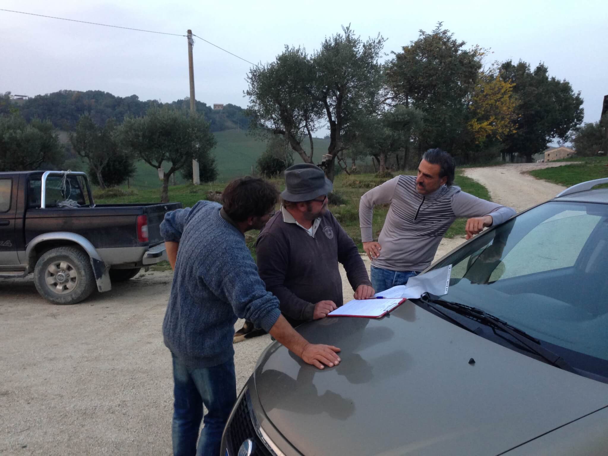Italian neighbors signing contract on hood of car
