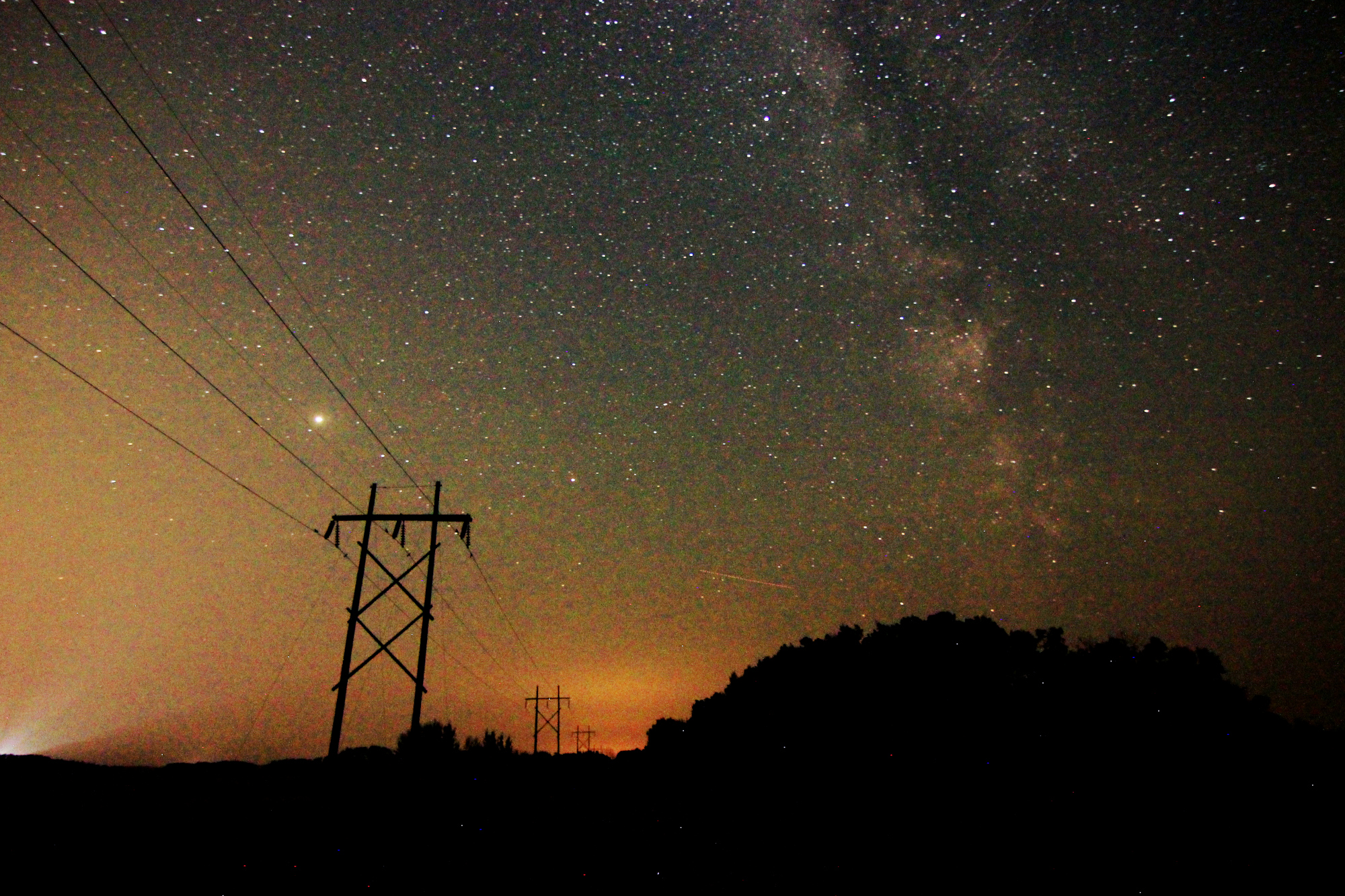The Milky Way above the road and trees