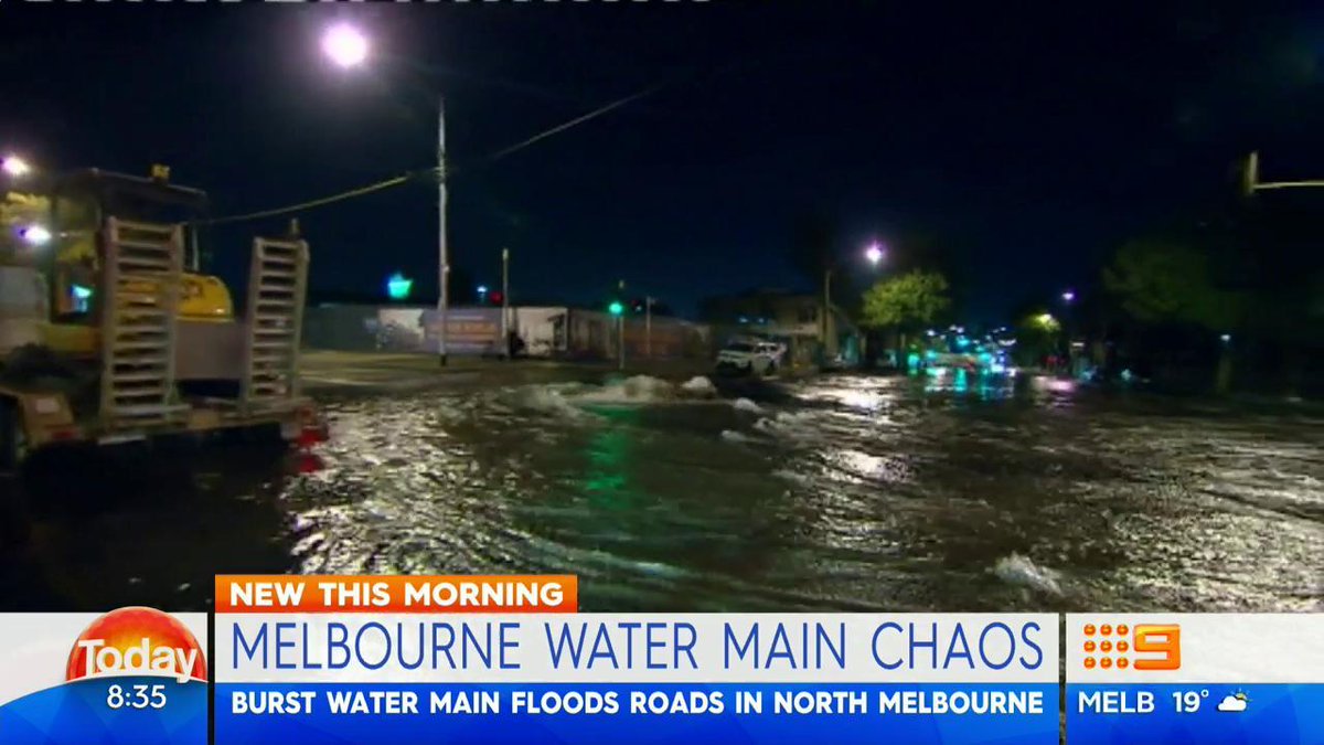 Burst water main has turned busy road into river at North Melbourne