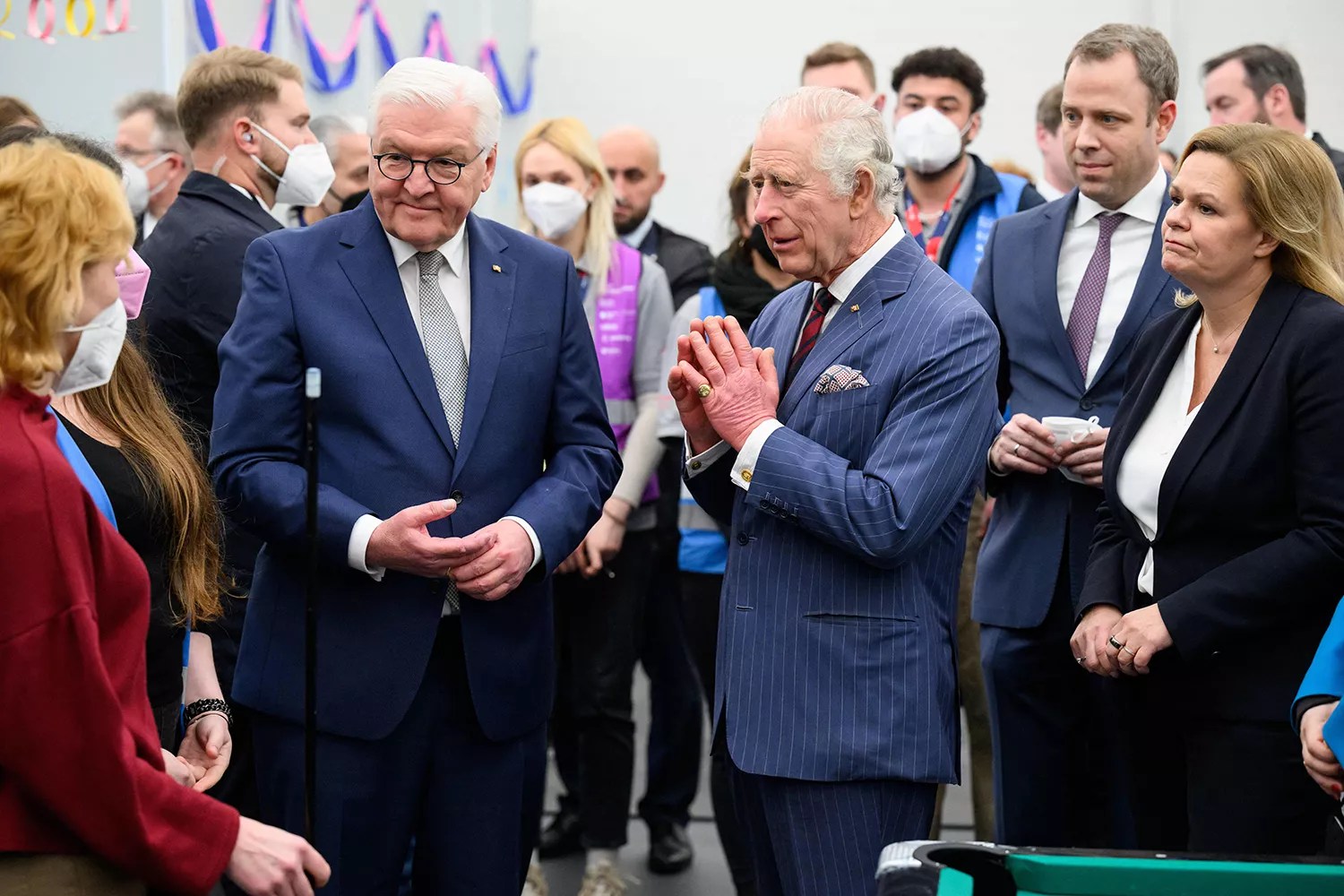 King Charles III (C), German President Frank-Walter Steinmeier (L) and German Interior Minister Nancy Faeser (R) visit the Ukraine Arrival Centre Tegel for Ukrainian refugees in Berlin